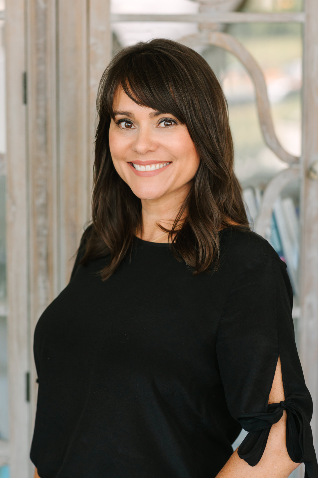 Professional headshot of a woman in a black top at The Sapphire Suite